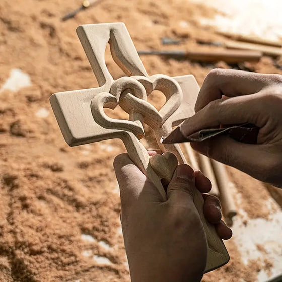 Kreuz aus Kiefernholz mit verschlungenen Herzen